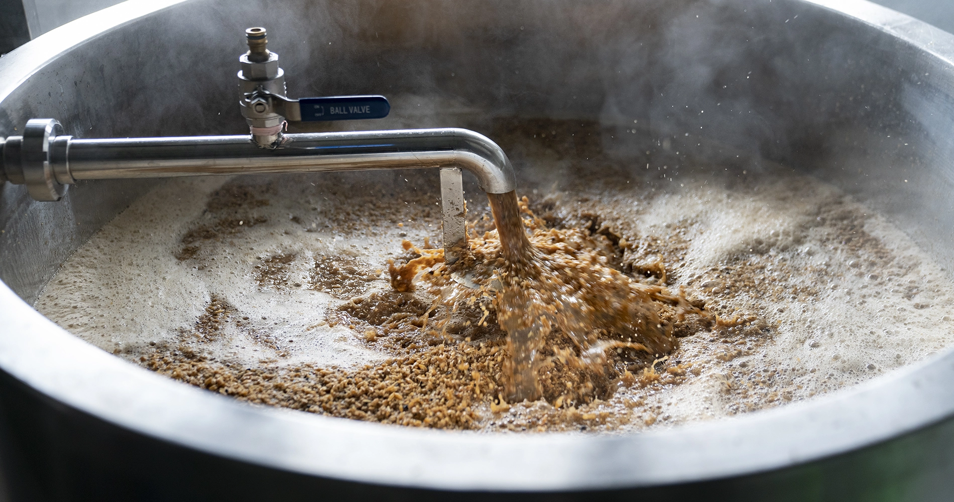 Proceso de elaboración de cerveza artesana con la mezcla de ingredientes en un recipente